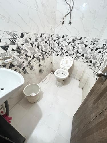 a bathroom with a toilet and a sink at S R Hotel in Surat