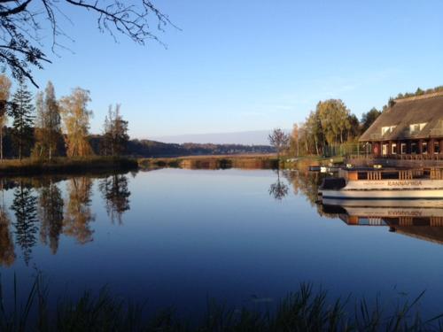 a boat is docked on a lake next to a house at Sammuli Holiday Village in Viljandi