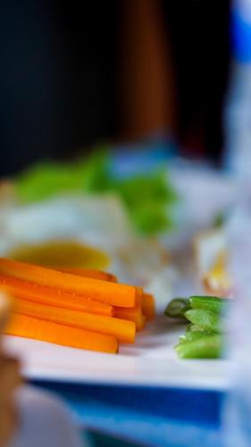 a plate of carrots and greens on a table at Little Haven Cottage in Sigiriya