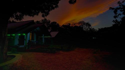 a house at night with a rainbow in the sky at Little Haven Cottage in Sigiriya