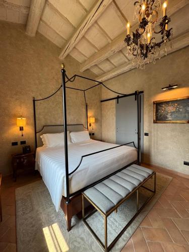 a bedroom with a large bed and a chandelier at Villa Petriolo - Small Luxury Hotels of the World in Cerreto Guidi