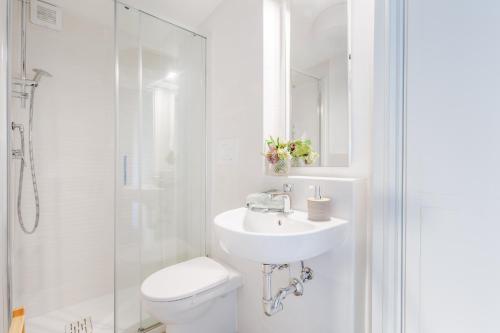 a white bathroom with a toilet and a sink at Villa Podere Falcione in San Quirico di Moriano