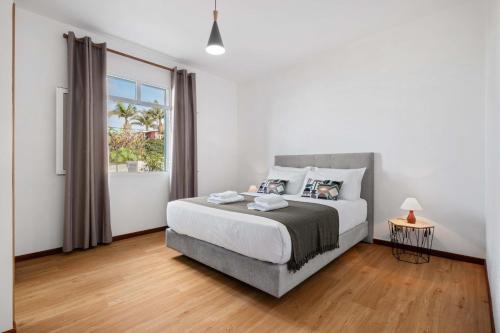 a white bedroom with a bed and a window at Villa Por do Sol in Relógio do Poiso