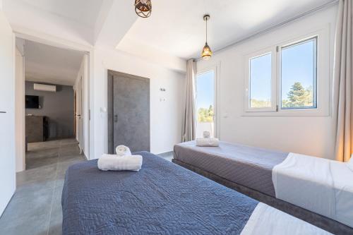 Dos camas en una habitación con dos ventanas. en Starry Sky Luxury Apartment 6, en Áno Lefkímmi
