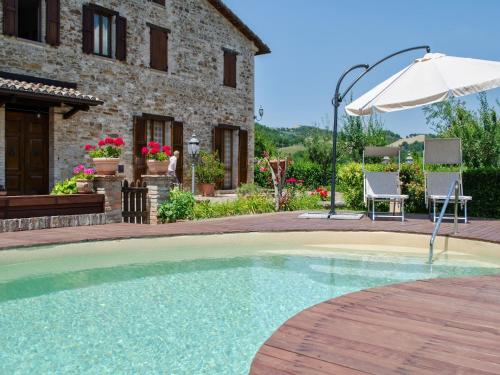 a swimming pool in front of a house with an umbrella at Pet-Friendly Villa with Pool in Urbino