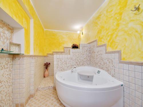 a bathroom with a white tub and yellow walls at Pet-Friendly Villa with Pool in Urbino