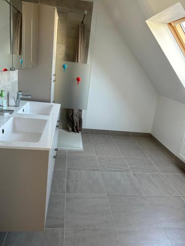 a white kitchen with a sink and a staircase at La gildasienne in Saint-Gildas-de-Rhuys