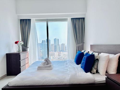 a bedroom with a large bed with a large window at Urban Oasis 1BR Apartment in Gate Towers in Abu Dhabi