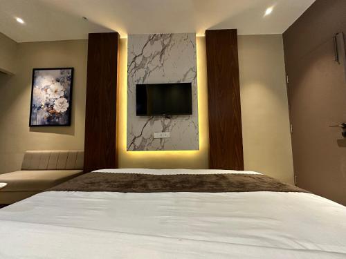 a bedroom with a bed and a tv on the wall at Hotel Casa Inn in Indore