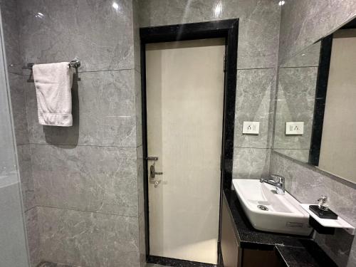 a bathroom with a sink and a shower backdoor at Hotel Casa Inn in Indore