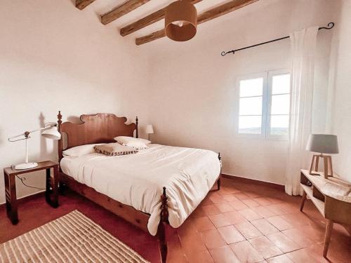 a bedroom with a large bed and a window at Son Pere - Romantic Hilltop Stay in Ferreries