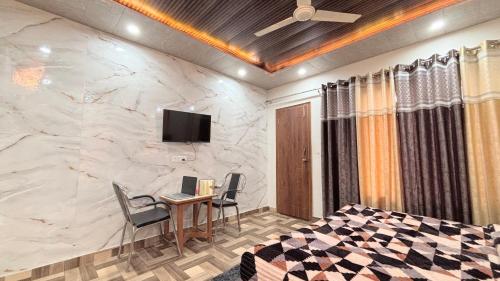 a room with a desk and a tv on a marble wall at TreeHouse Kasauli Operated By Splendid Hotels I Vacations I Family Groups & Events I Forest Treks I Memories I in Kasauli