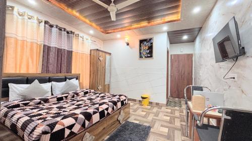 a bedroom with a bed and a tv on a wall at TreeHouse Kasauli Operated By Splendid Hotels I Vacations I Family Groups & Events I Forest Treks I Memories I in Kasauli