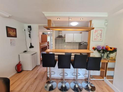 a kitchen with a counter and some black bar stools at Pause Nature N in La Calamine