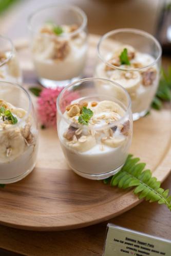 a group of small bowls of food on a wooden plate at Elite Atoll Serviced Apartments Phuket in Rawai Beach