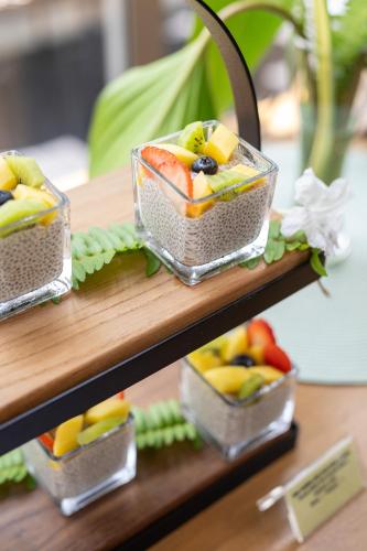 three plastic containers of fruit sitting on a shelf at Elite Atoll Serviced Apartments Phuket in Rawai Beach