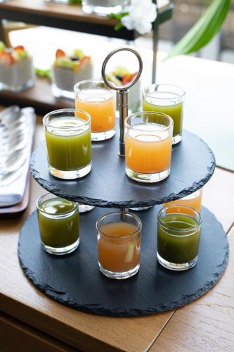 a three tiered tray with different colored glasses on it at Elite Atoll Serviced Apartments Phuket in Rawai Beach