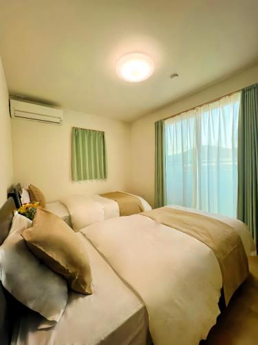 a hotel room with two beds and a window at 藍遊び in Fukuoka