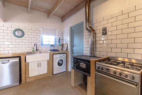 a kitchen with a stove and a washing machine at Die Veldmuis in Paternoster