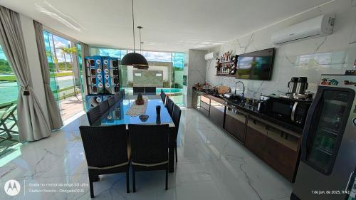 una cucina con un tavolo con sedie e un bancone di PWG Cânions - Sua casa de temporada no paraíso a Piranhas