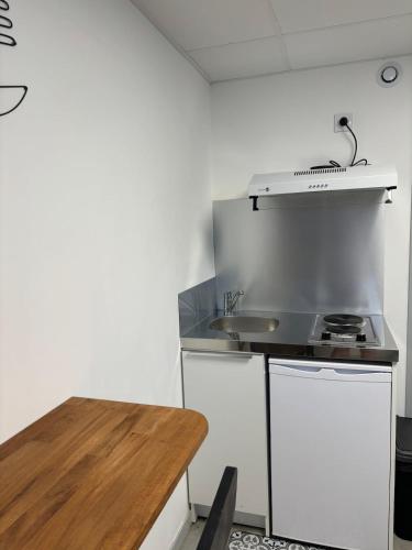 a kitchen with a sink and a wooden table at Studio, quiet and secure in ZA in Chaingy