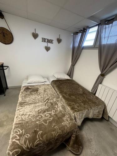 a bedroom with two beds and a clock on the wall at Studio, quiet and secure in ZA in Chaingy