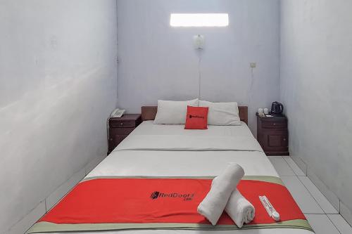 a bedroom with a bed with two towels on it at RedDoorz Syariah at Hotel Adi Sederhana near Stasiun Jatibarang in Sleman