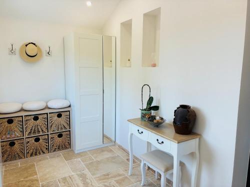 une salle de bain blanche avec une table et un meuble dans l'établissement Gîte normand climatisé avec piscine privée, à Condé-sur-Seulles