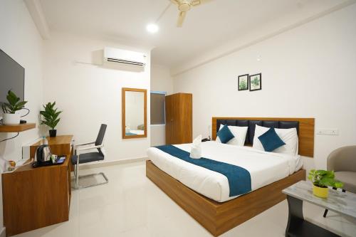 Un dormitorio con una cama y un escritorio en una habitación. en Elite Hotel HITECH, en Hyderabad
