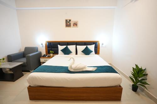 a bedroom with a bed with a swan on it at Elite Hotel HITECH in Hyderabad
