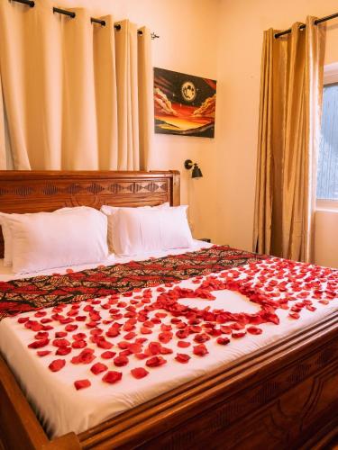 a bed with roses on it with a bunch of flowers at Pajevista villa in Paje