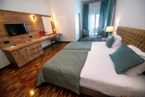 a hotel room with a bed and a television at DOME Hotel & Casino Central Kyrenia in Kérynia