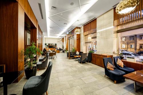 a lobby of a restaurant with chairs and tables at Holiday Inn Baku by IHG in Baku