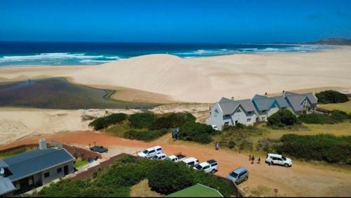 an aerial view of a beach with a house and cars at Ebb & Flow Beach House in Oyster Bay