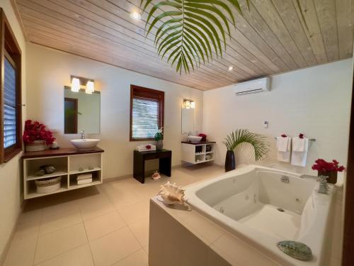 a large bathroom with a tub and a sink at The Hideaway Collection at Nonsuch Bay in Gaynors