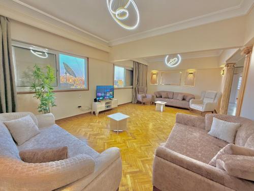 a living room with two couches and a tv at Golden mile - Downtown Cairo in Cairo