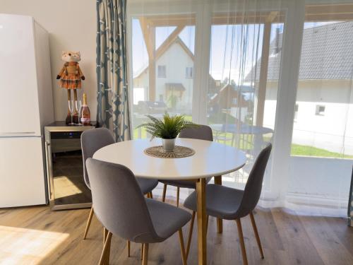 a dining room with a table and chairs and a window at Lipno - Lakeside Village - Větrník in Frymburk
