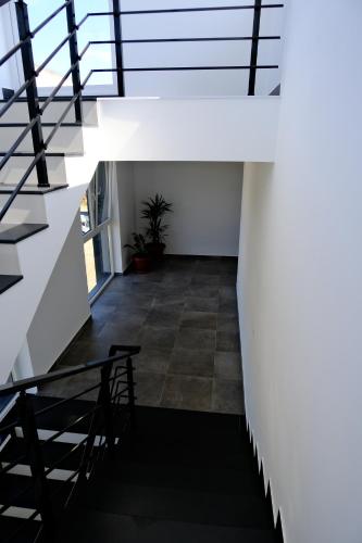 a staircase in a house with white walls and a stair case at Eden House in Kukës