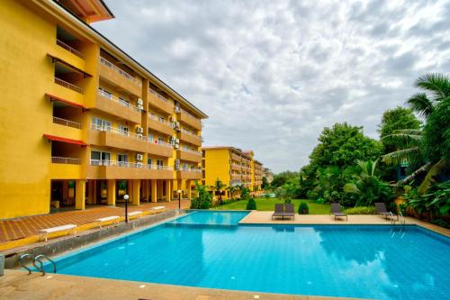 a swimming pool in front of a building at Lush View 2BHK Apartments in Candolim in Candolim
