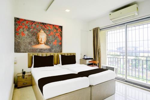a bedroom with a large bed with a painting on the wall at Collection O Viviana Mall Thane West Formerly Athithi Stays in Thane