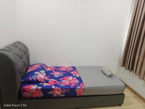 a bed with a floral blanket on it in a room at HoMestaY Kulim Seri Rambai in Kulim