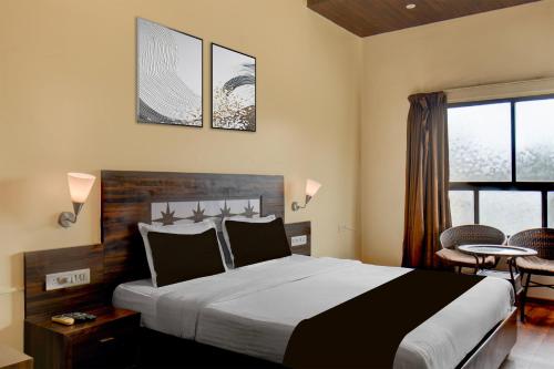 a bedroom with a large bed and a table and chairs at Super Townhouse Oak Sinhgad Road Crossway Formerly Popular Hotel in Pune