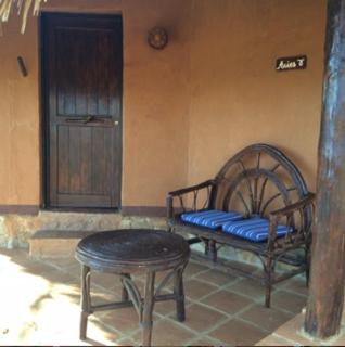a bench in a room with a table and a door at Hotel Bahía de la Luna in Arroyo Cruz