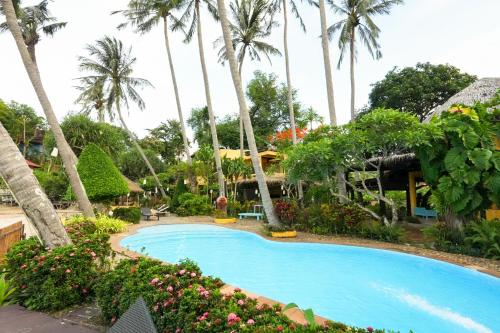 a swimming pool at a resort with palm trees at Vacation Village Phra Nang Lanta - SHA Extra Plus in Ko Lanta