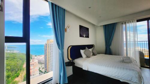 フーコックにあるAura Aparmentのベッドと大きな窓のある寝室