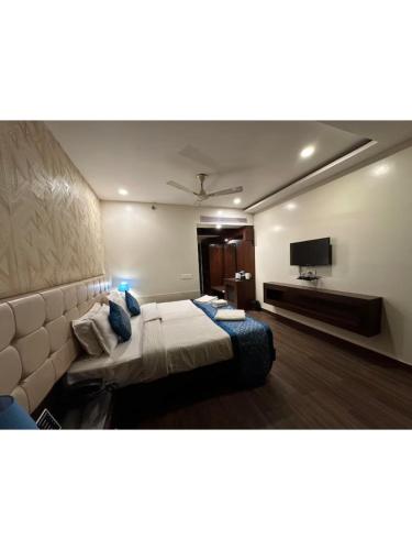a hotel room with a bed and a flat screen tv at Hotel The Westinn in Varanasi