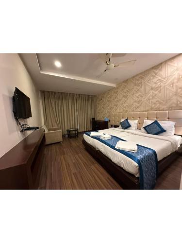a hotel room with a large bed with blue pillows at Hotel The Westinn in Varanasi