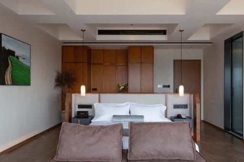 a bedroom with a bed and two chairs at Tianya Wuxi river Hotel (Jiefangbei ) in Nan'an
