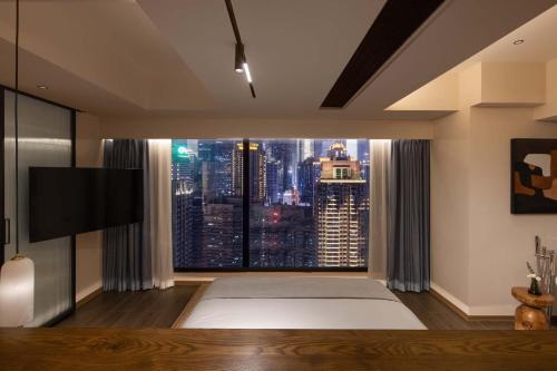 a living room with a large window with a city view at Tianya Wuxi river Hotel (Jiefangbei ) in Nan'an