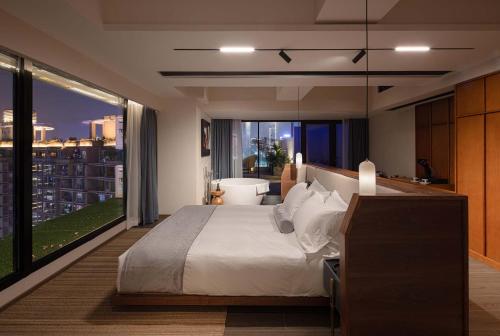 a bedroom with a bed and a view of a city at Tianya Wuxi river Hotel (Jiefangbei ) in Nan'an